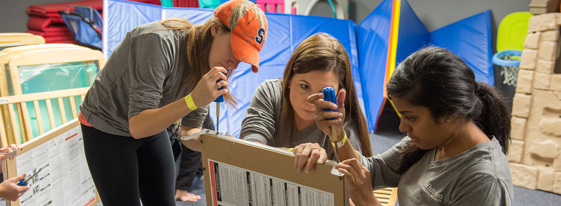 Student volunteers assembling furniture banner